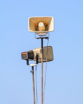 Old loudspeakers on steel pole on blue sky