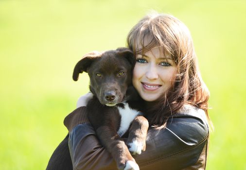 Beautiful young woman holding small cute dog