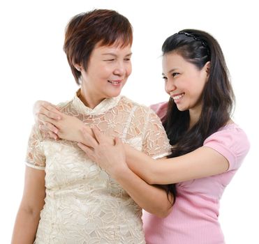 Adult daughter embraces mother isolated on white background. Mixed race Asian family portrait. 
