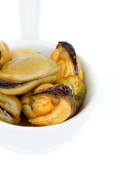 Delicious Smoked Mussels with Olive Oil in White Bowl closeup on white background