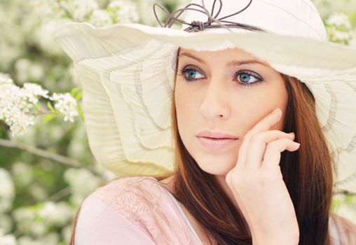 Beautiful girl posing over spring flowers background