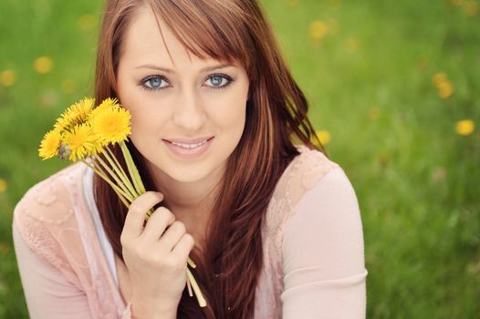 Beautiful girl posing over spring flowers background