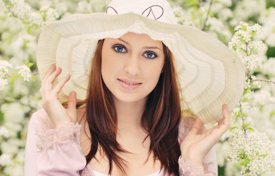 Beautiful girl posing over spring flowers background