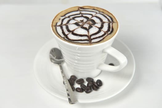 Large cup of coffee decorated with milk froth and chocolate drawing