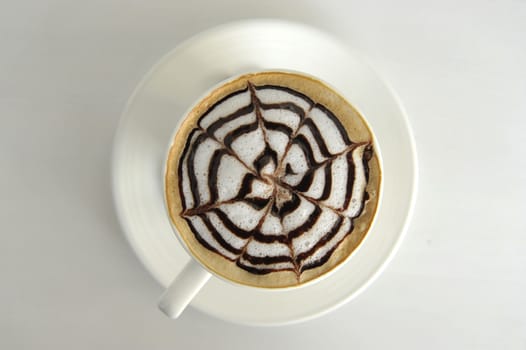 Large cup of coffee decorated with milk froth and chocolate drawing