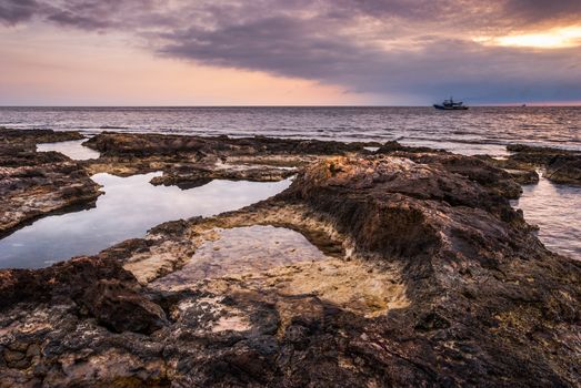 Sunset over the Sea and Rocky Coast with Trawler in Mahdia, Tunisia