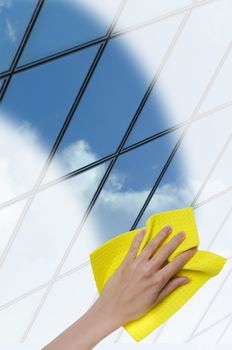 hand cleaning window making it easier to glass office building through it cropped vertically