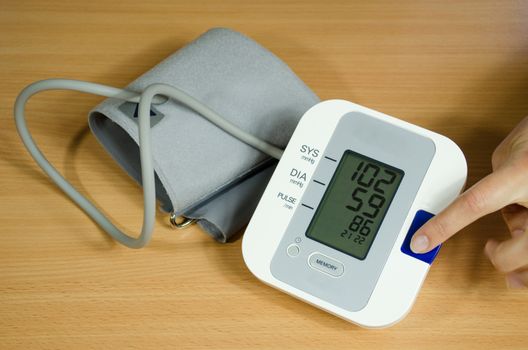 measuring blood pressure and female finger presses the start button