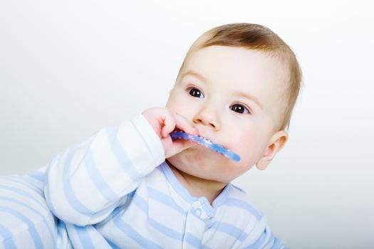 Studio photography. Little baby boy gnaws toy