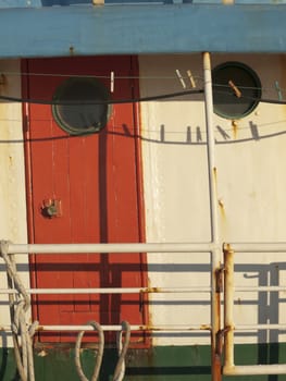 empty clothes pegs before cabin door of an old fishing boat