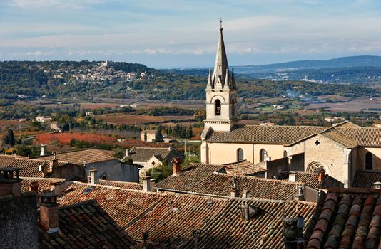 Luberon landscape view with cathedral of Bonnieux and Lacoste village in the back, Provence, France