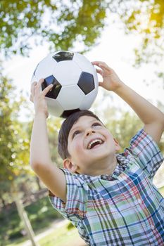 Cute Young Boy Playing with Soccer Ball Outdoors in the Park.