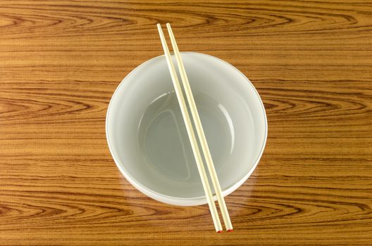empty white bowl with chopstick on wood table background