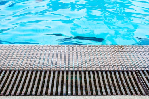 Swimming pool side with drain