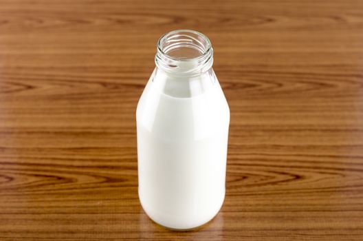 milk in a glass of bottle on wood table background