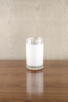 milk in a glass on wood background