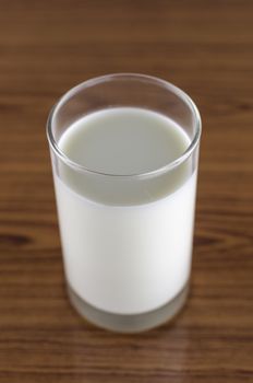 milk in a glass on wood background