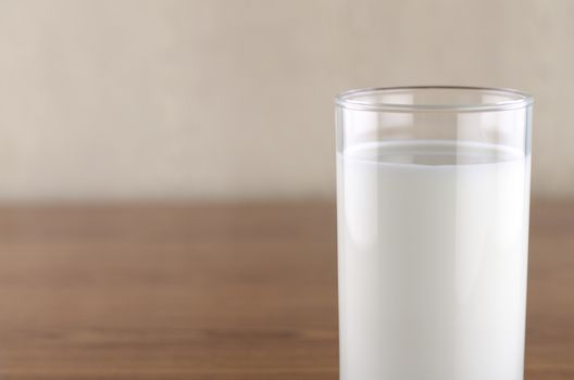 milk in a glass on wood background