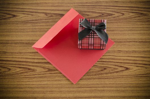 red gift box and envelope on wood background