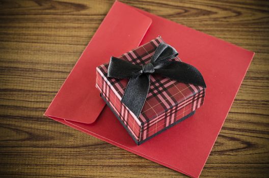 red gift box and envelope on wood background