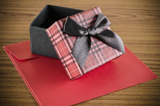 red gift box and envelope on wood background