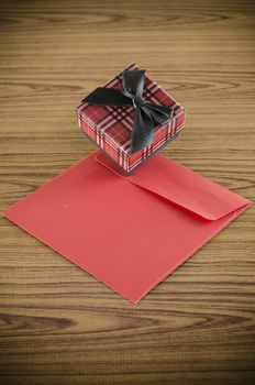 red gift box and envelope on wood background