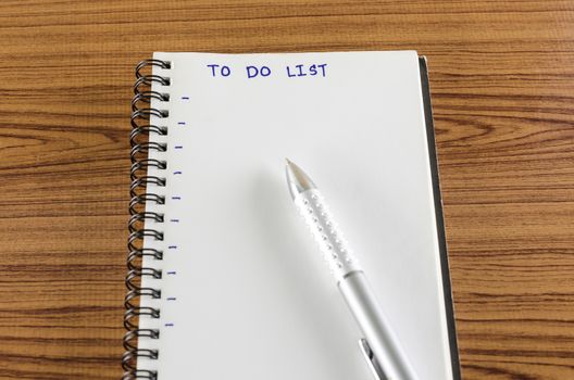 notebook and pen with word to do list on wood background