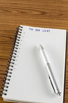 notebook and pen with word to do list on wood background