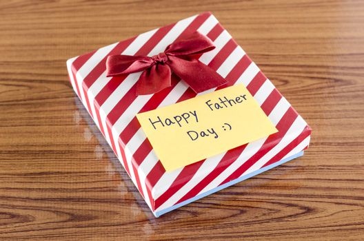 gift box with card write happy father day on wood background