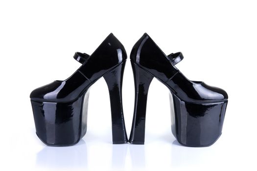 Black Dominatrix style high heel fetish shoes, isolated on white background, natural shadow and reflection 