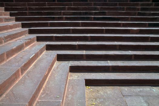 morning sunlight on red sandstone stairs creates light and shadow design in lines