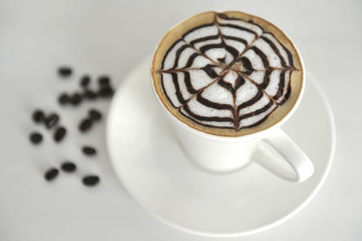 Large cup of coffee decorated with milk froth and chocolate drawing