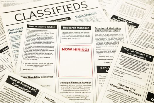 newspaper with advertisements and classifieds ads for vacancy, now hiring