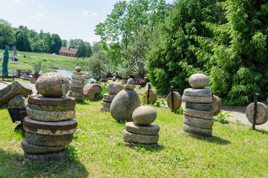 rural millstones and stone figure in the meadow landscape of the park