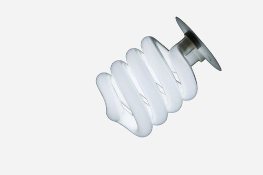 Glowing Spiral CFL Lamp isolated against white background in diagonal composition