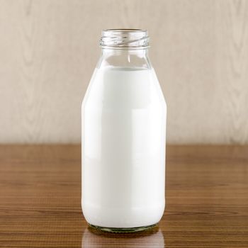 milk in a glass of bottle on wood table background