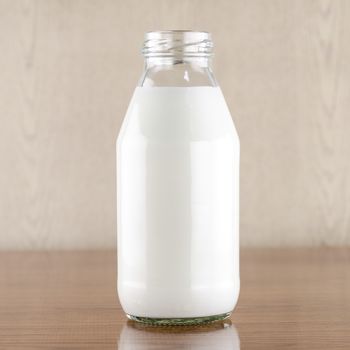 milk in a glass of bottle on wood table background