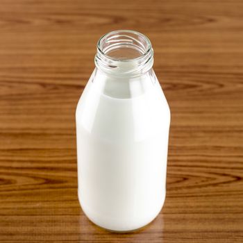 milk in a glass of bottle on wood table background