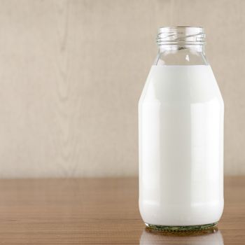milk in a glass of bottle on wood table background