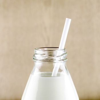 milk with straw in a glass of bottle