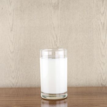 milk in a glass on wood background