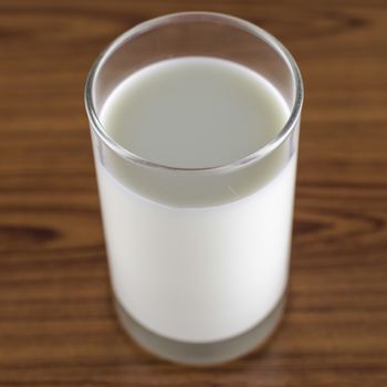 milk in a glass on wood background