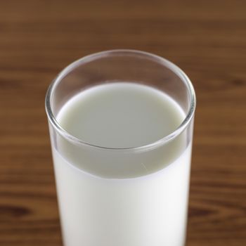 milk in a glass on wood background
