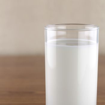 milk in a glass on wood background