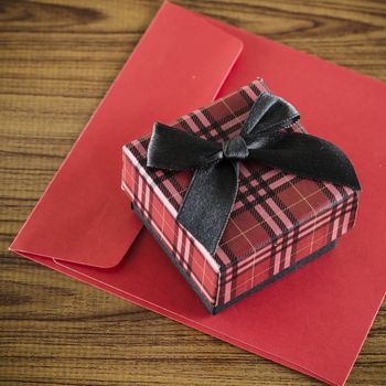 red gift box and envelope on wood background