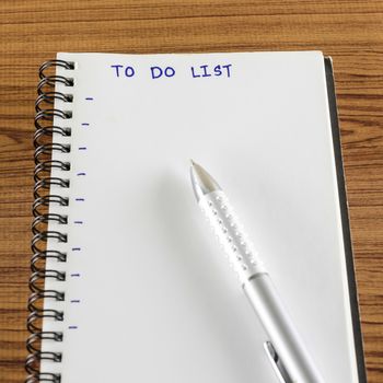 notebook and pen with word to do list on wood background