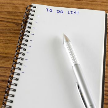 notebook and pen with word to do list on wood background