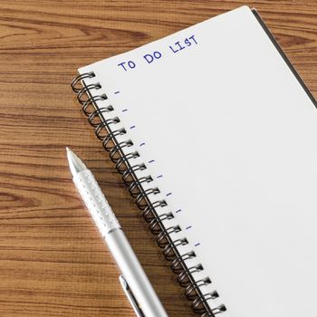 notebook and pen with word to do list on wood background