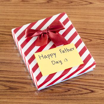 gift box with card write happy father day on wood background
