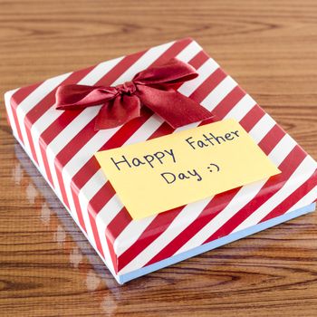 gift box with card write happy father day on wood background